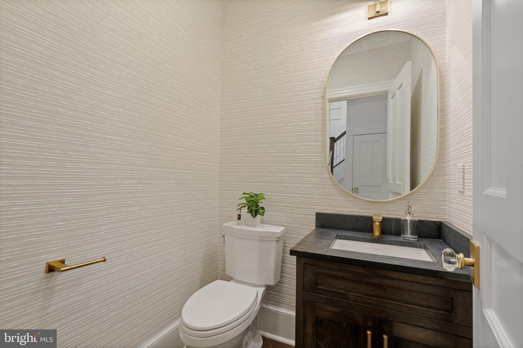 133 13th Street Northeast Washington, DC 20002 - Photo 11 of 41 a bathroom with a granite countertop toilet sink and mirror