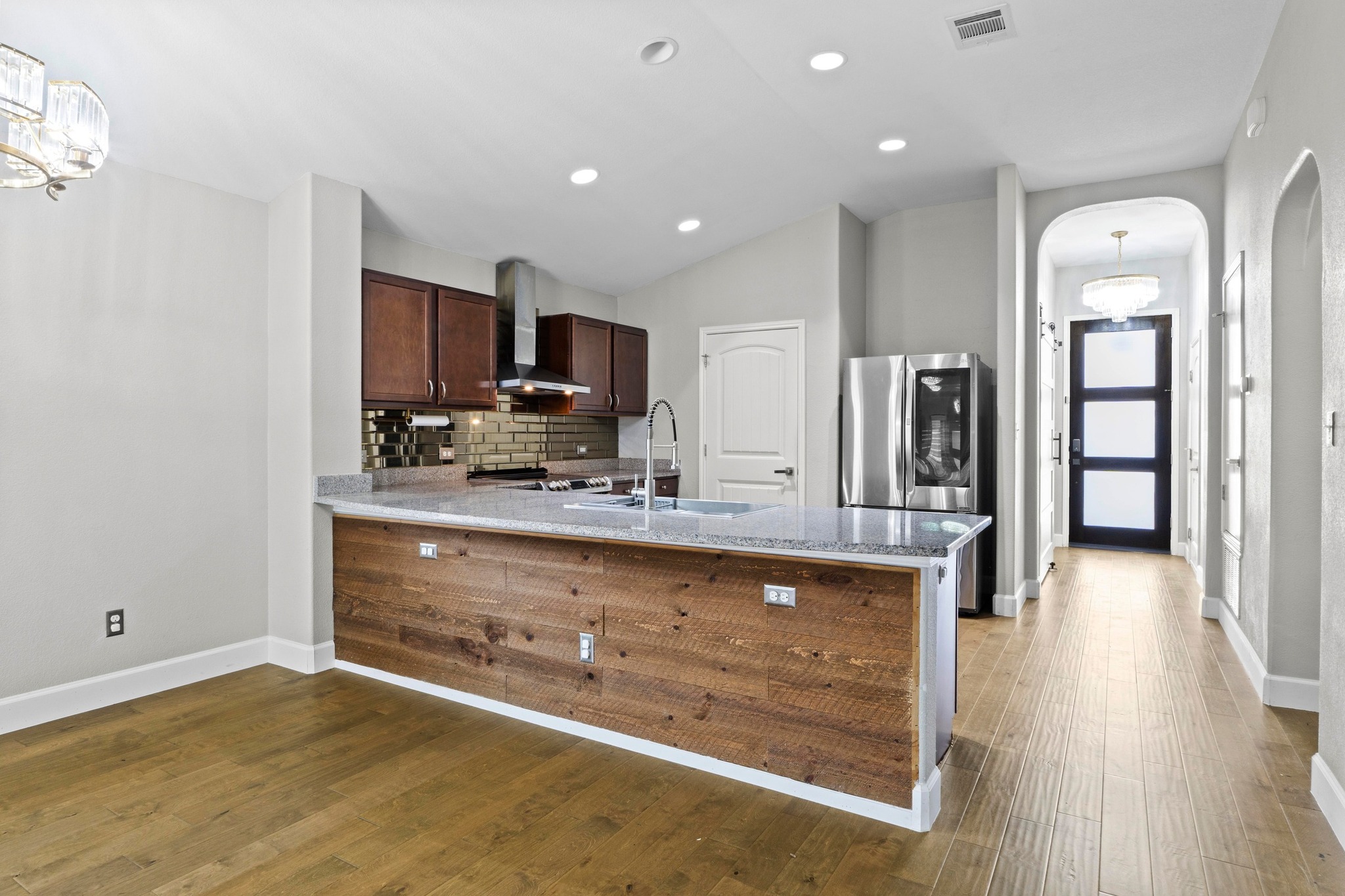 19004 Mangan Way Pflugerville, TX 78660 - Photo 11 of 38 The oversized kitchen island features a wood plank wrap and a deep undermount sink. With plenty of breakfast bar seating and warm cabinetry, this kitchen combines functionality with exceptional design.