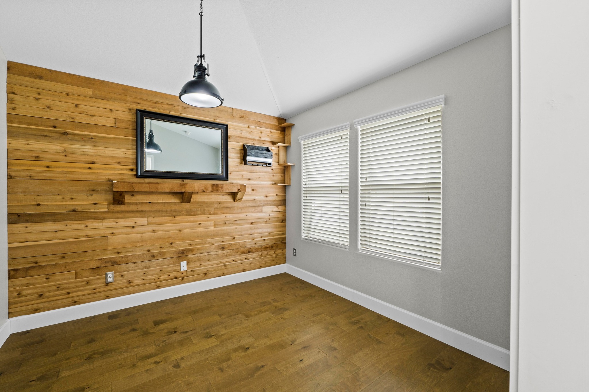 19004 Mangan Way Pflugerville, TX 78660 - Photo 17 of 38 Perfect for a home office or hobby room, this space features a striking wood accent wall and built-in shelving. The large windows provide plenty of natural light.