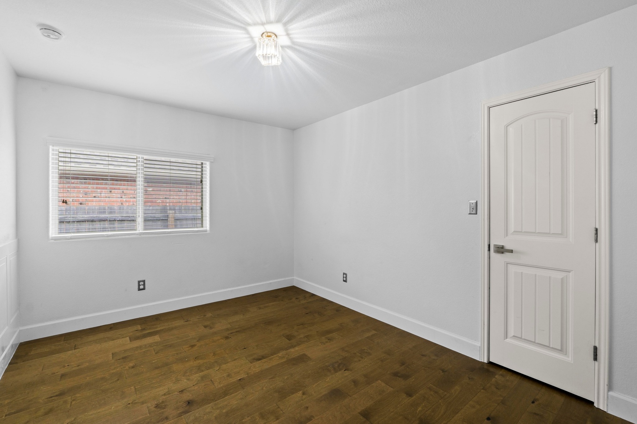 19004 Mangan Way Pflugerville, TX 78660 - Photo 23 of 38 This spacious secondary bedroom features beautiful hardwood-style flooring and a large window that fills the space with natural light. With a neutral color palette, it’s a versatile space perfect for a guest suite.