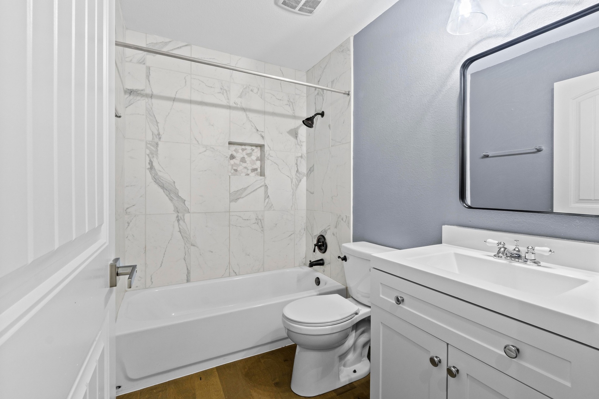 19004 Mangan Way Pflugerville, TX 78660 - Photo 24 of 38 The secondary bathroom is beautifully appointed with a modern vanity, sleek black-framed mirror, and a designer tiled shower with a built-in niche. No detail was overlooked in this move-in-ready home.