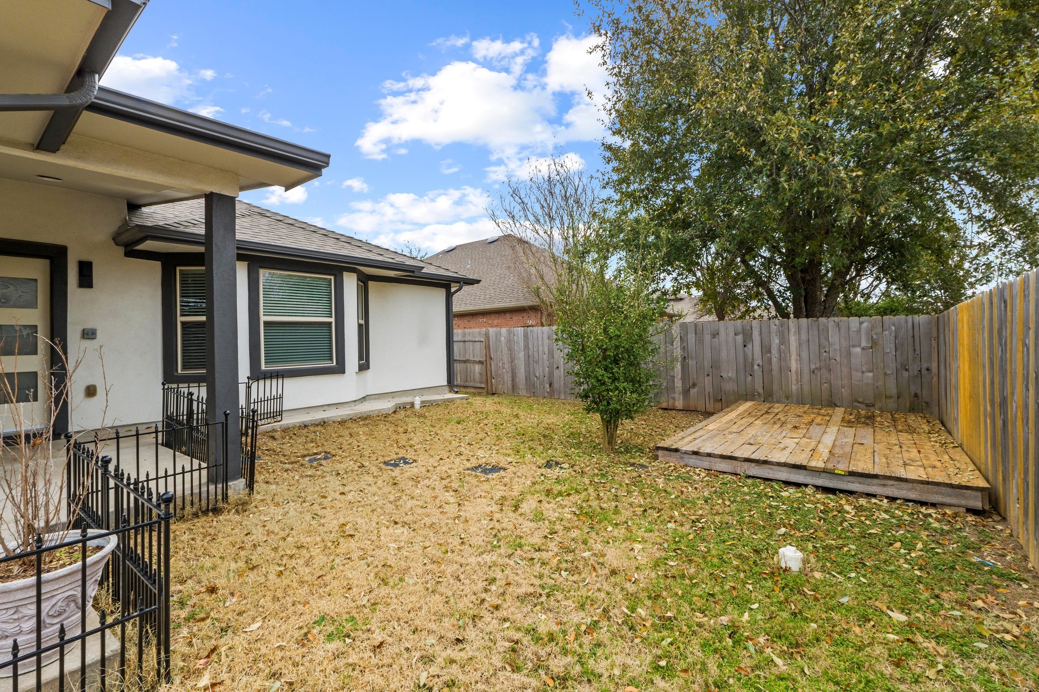 19004 Mangan Way Pflugerville, TX 78660 - Photo 31 of 38 The backyard features a versatile wooden platform, perfect for additional seating.
