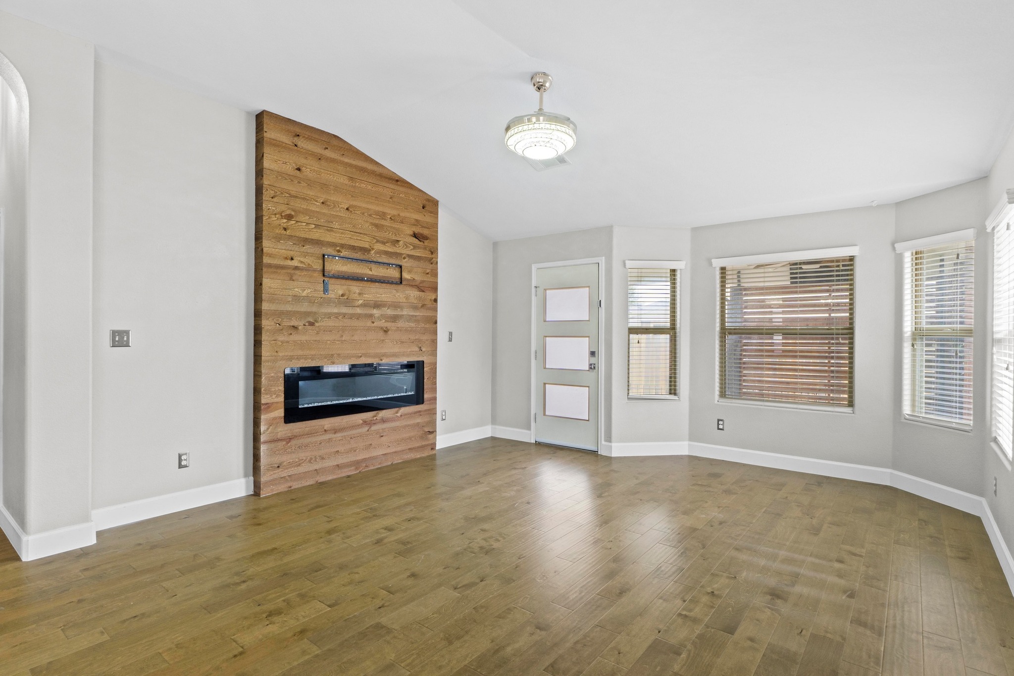 19004 Mangan Way Pflugerville, TX 78660 - Photo 8 of 38 The focal point of the living room is a stunning floor-to-ceiling wood accent wall featuring a sleek, modern electric fireplace.