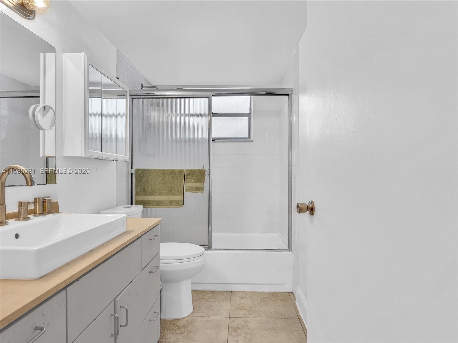 1236 Alton Road, Unit 304 Miami Beach, FL 33139 - Photo 17 of 28 a bathroom with a sink a toilet and shower