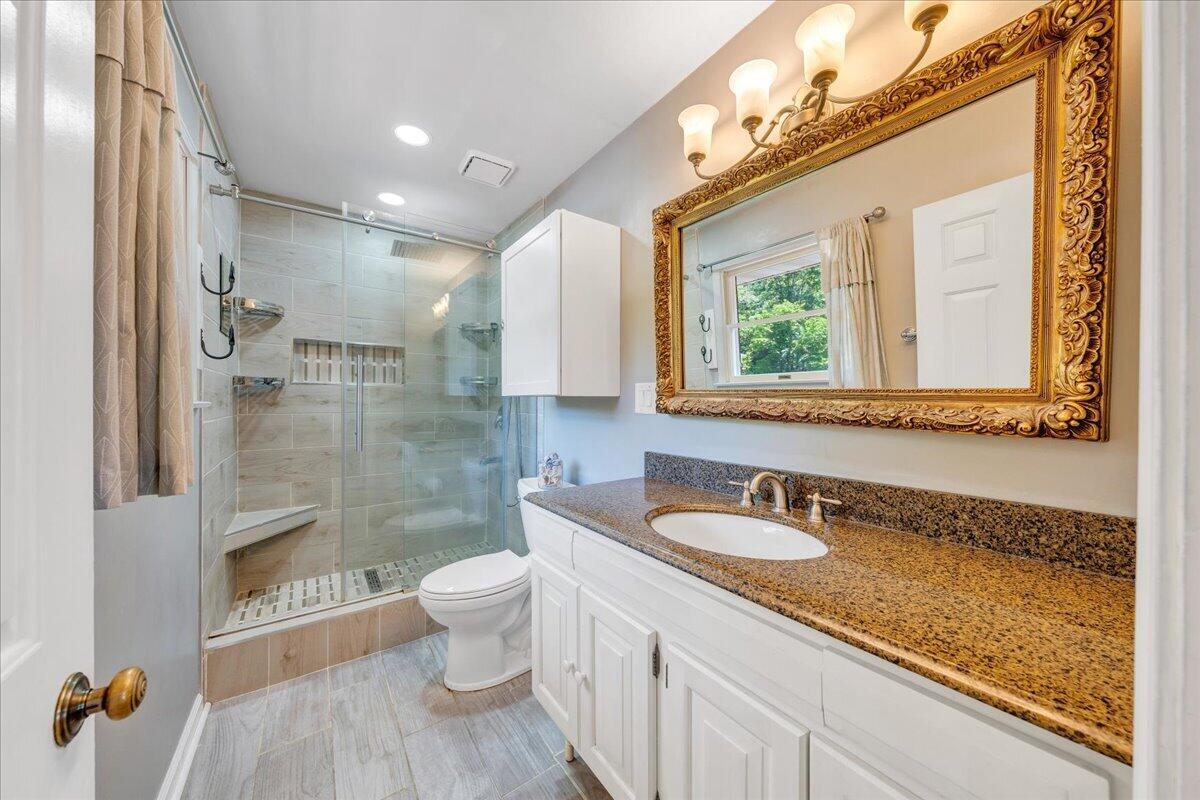4434 Rosecrest Road Roanoke, VA 24018 - Photo 21 of 48 a bathroom with a granite countertop sink a toilet a mirror and shower