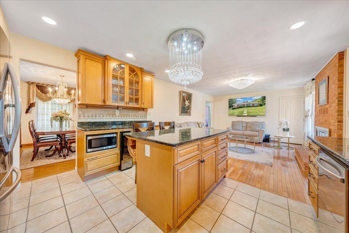 4434 Rosecrest Road Roanoke, VA 24018 - Photo 10 of 48 a kitchen with stainless steel appliances granite countertop a stove top oven a sink dishwasher and white cabinets with wooden floor