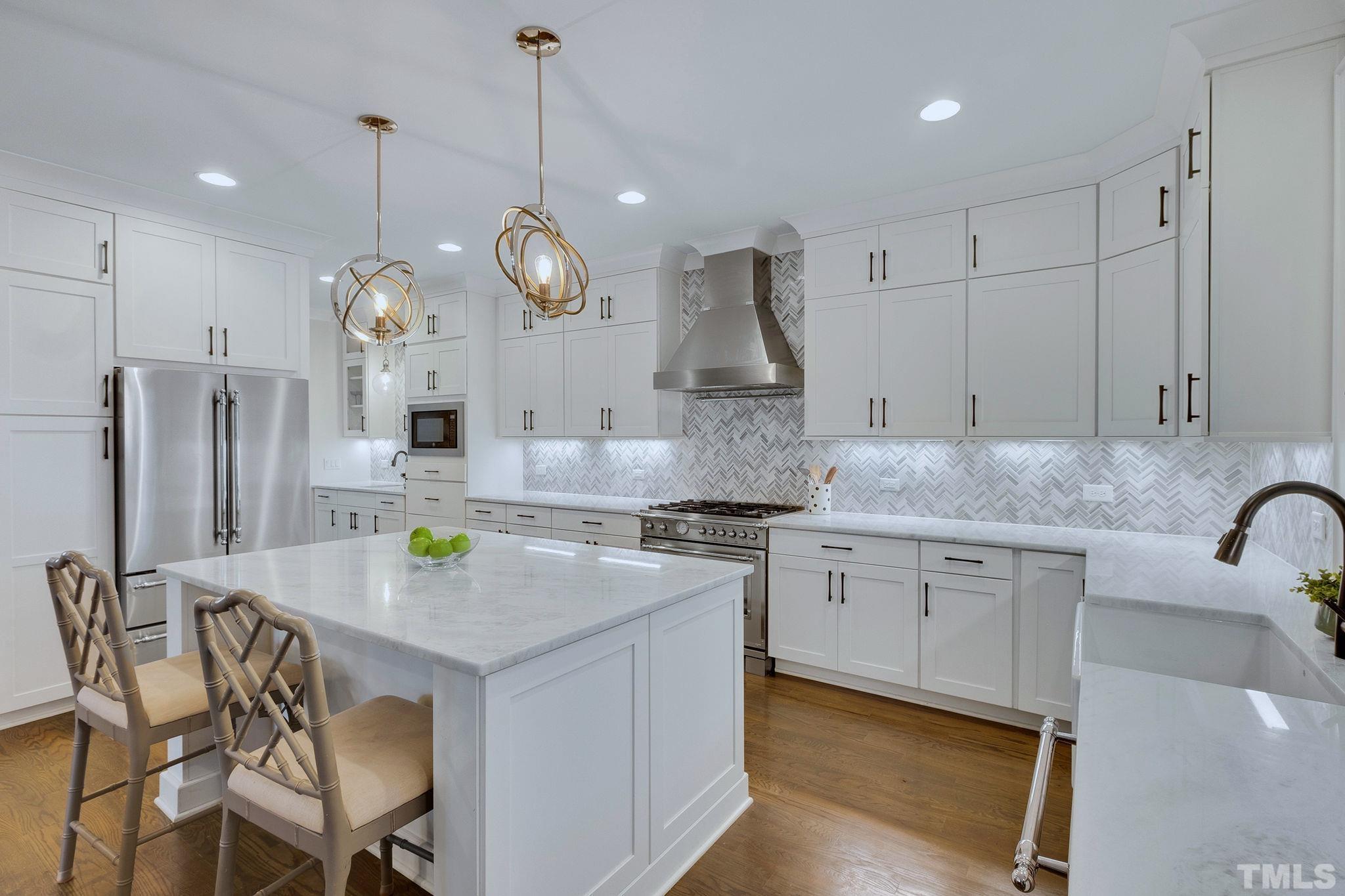 3025 Lewis Farm Road Raleigh, NC 27607 - Photo 2 of 42 a kitchen with stainless steel appliances granite countertop a stove a sink a refrigerator a center island a dining table and chairs