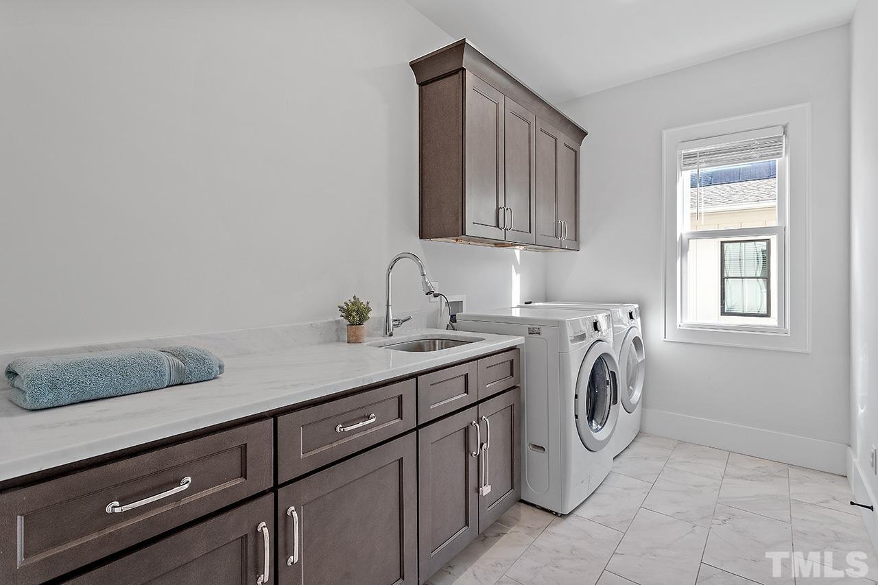 3025 Lewis Farm Road Raleigh, NC 27607 - Photo 24 of 42 a utility room with cabinets washer and dryer