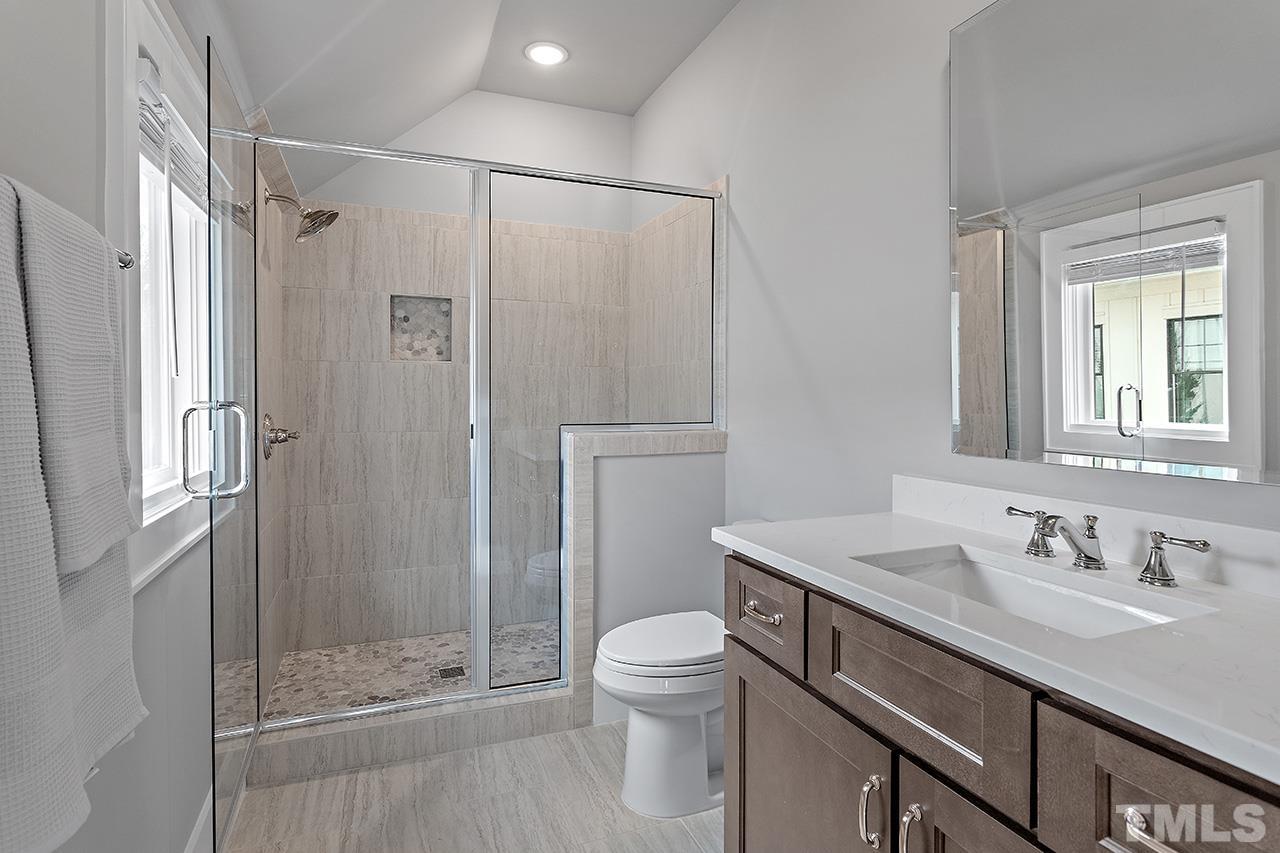 3025 Lewis Farm Road Raleigh, NC 27607 - Photo 35 of 42 a bathroom with a shower sink vanity mirror and toilet