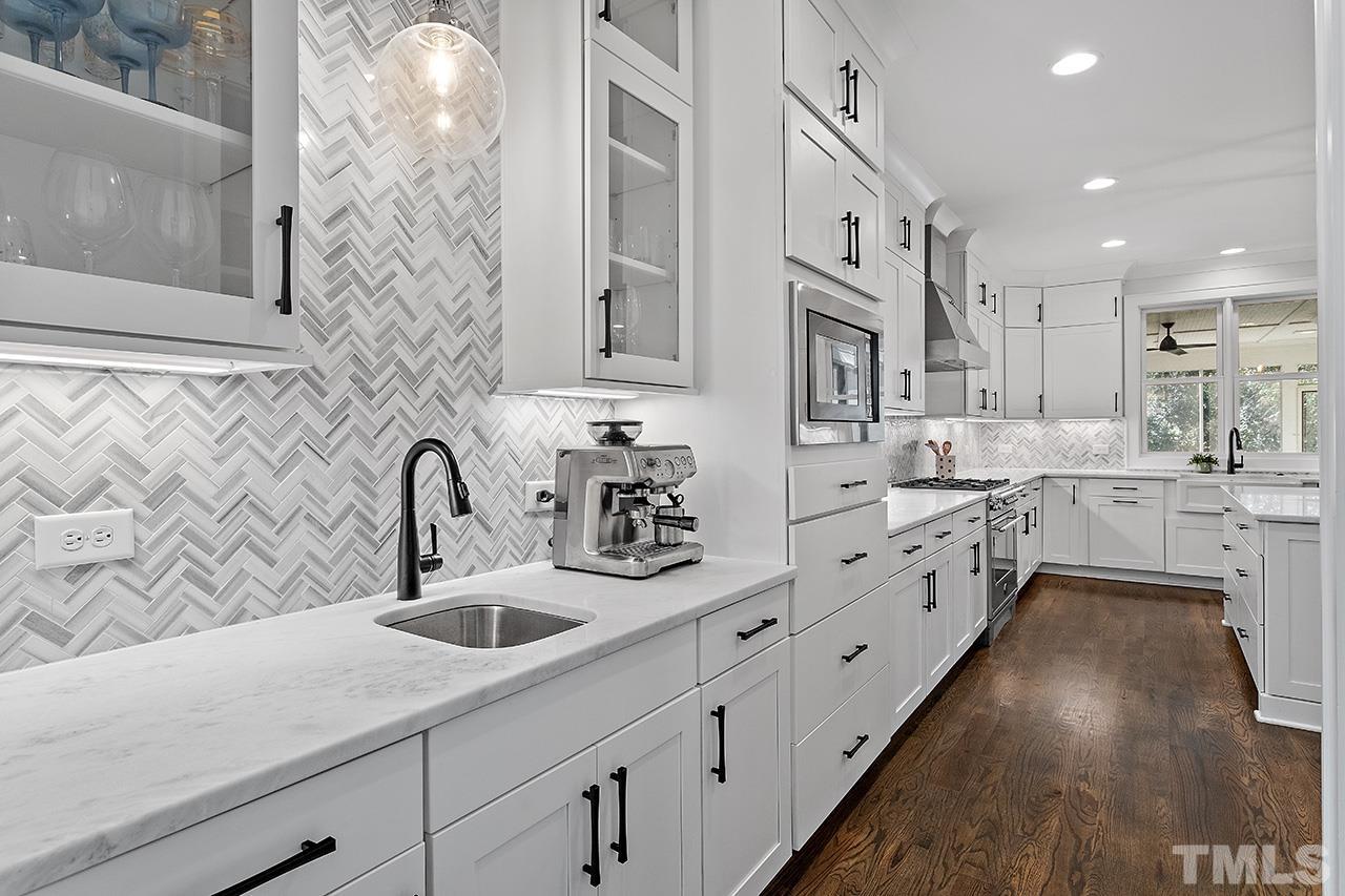3025 Lewis Farm Road Raleigh, NC 27607 - Photo 4 of 42 a kitchen with stainless steel appliances sink a microwave and cabinets
