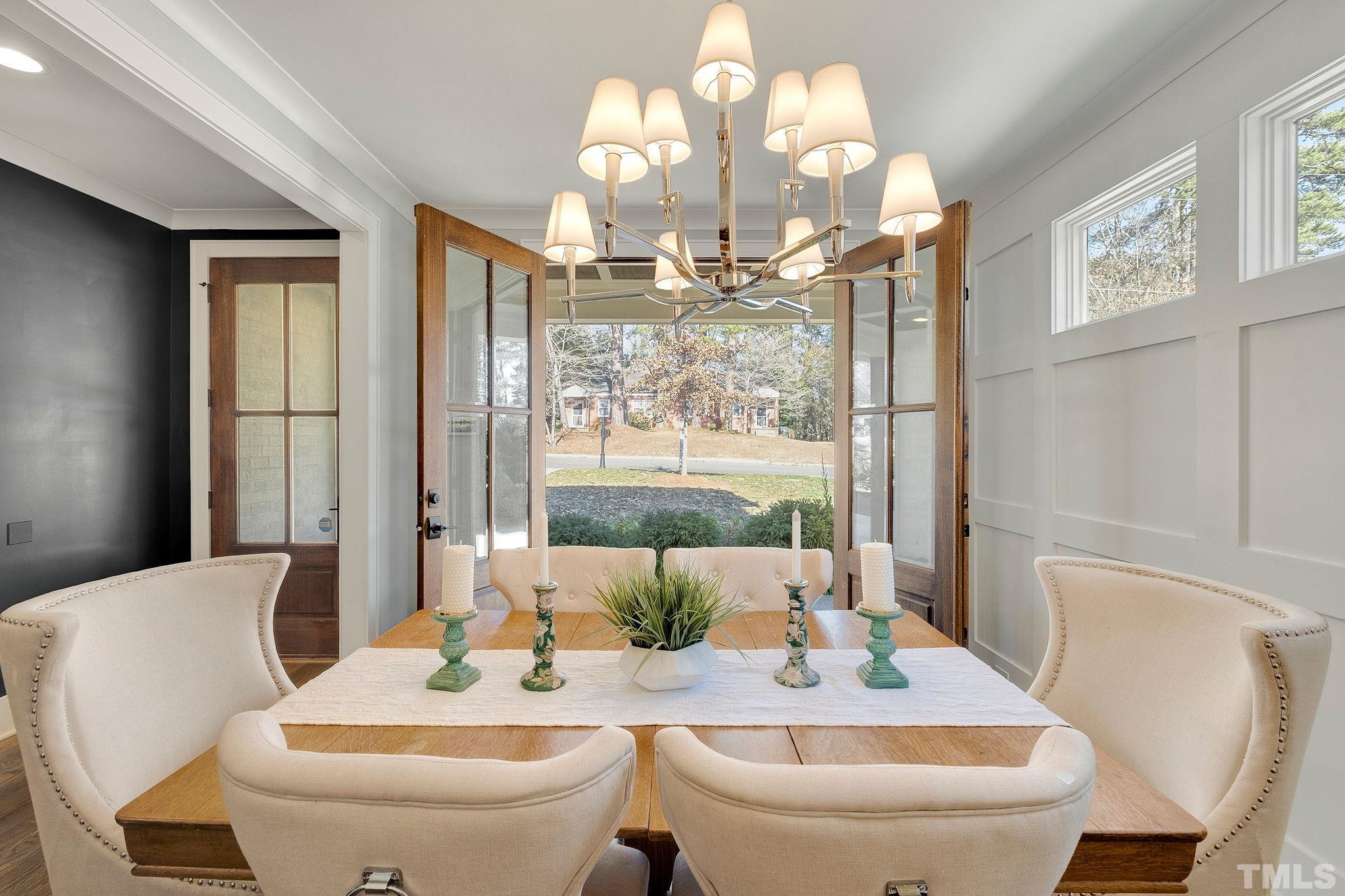 3025 Lewis Farm Road Raleigh, NC 27607 - Photo 7 of 42 a view of a dining room with furniture a chandelier and large windows