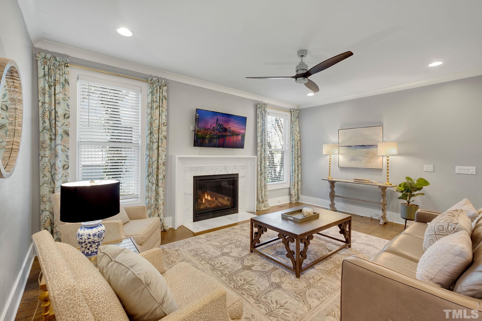 3025 Lewis Farm Road Raleigh, NC 27607 - Photo 8 of 42 a living room with furniture a flat screen tv and a fireplace