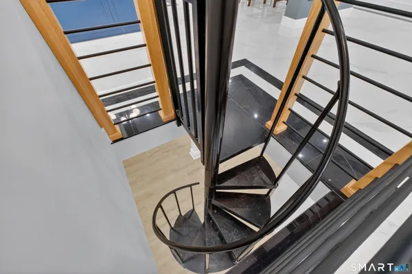 a view of staircase with white walls and black door