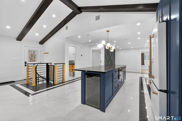 a kitchen with stainless steel appliances kitchen island granite countertop a refrigerator and a sink