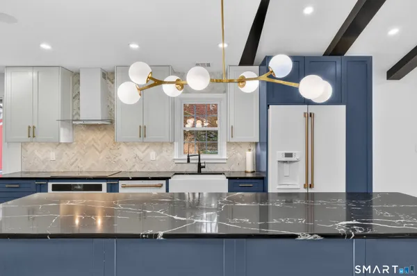 a kitchen with kitchen island granite countertop a sink cabinets and stainless steel appliances