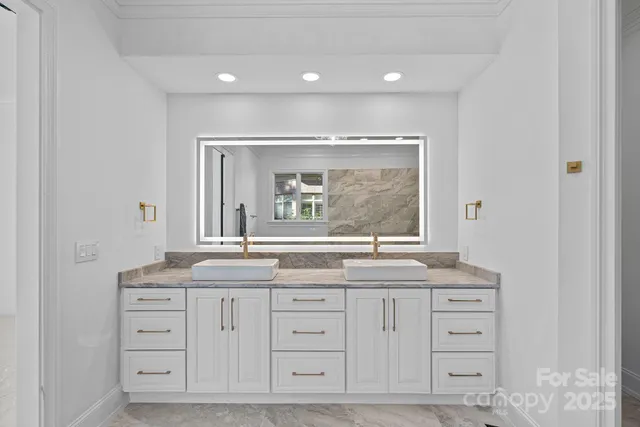 a bathroom with a granite countertop double vanity sink and mirror