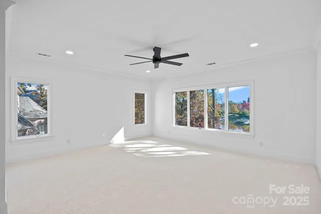 an empty room with a ceiling fan and window