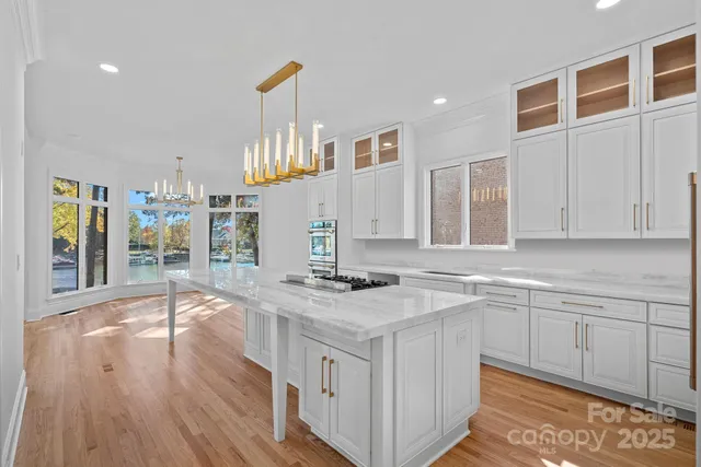 a kitchen that has a lot of cabinets in it and wooden floors