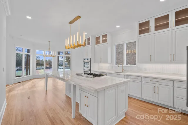 a kitchen with stainless steel appliances kitchen island granite countertop a stove a sink and a refrigerator