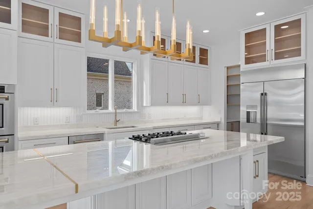 a kitchen with granite countertop white cabinets and stainless steel appliances