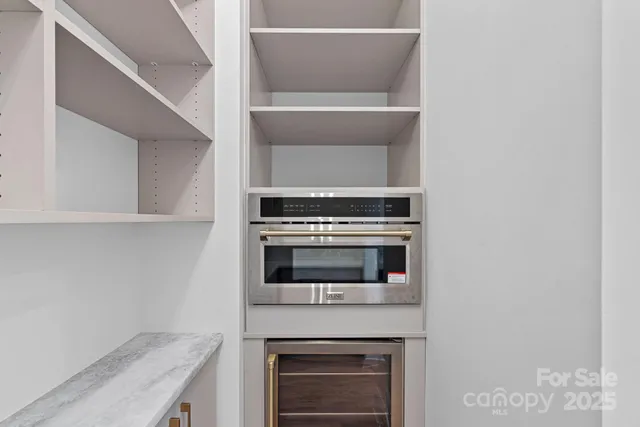 a kitchen with granite countertop white cabinets and stainless steel appliances