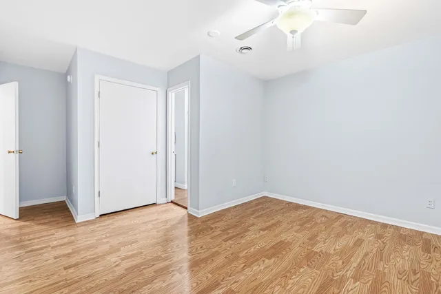 a view of empty room with wooden floor