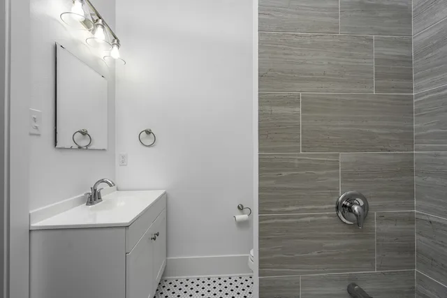 a bathroom with a sink a toilet and shower