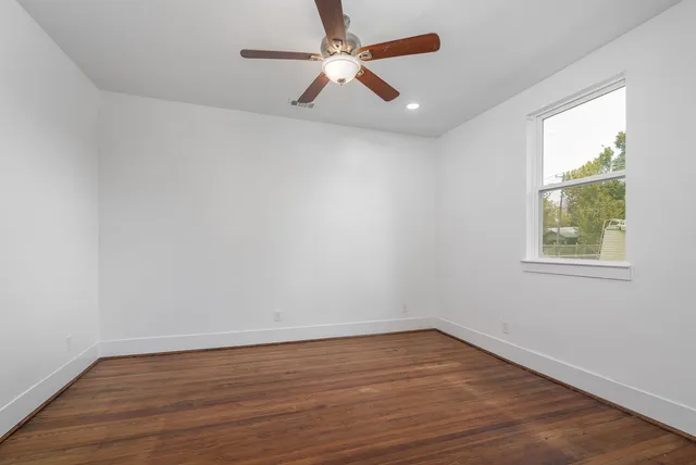 wooden floor in an empty room with a window