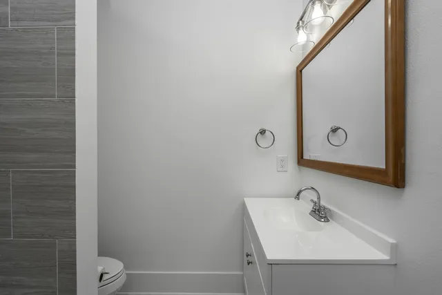 a bathroom with a sink a toilet and mirror