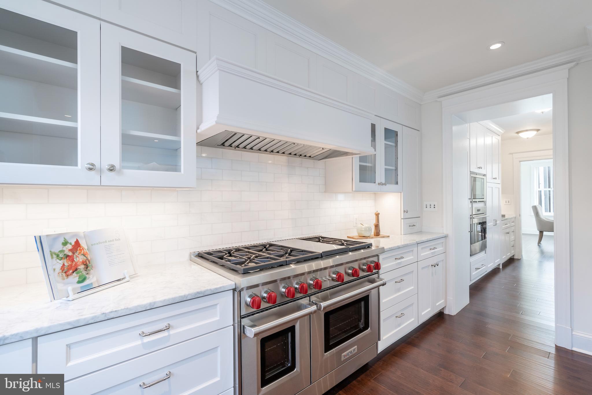 2715 N Street Northwest Washington, DC 20007 - Photo 16 of 41 a kitchen with stainless steel appliances a stove and white cabinets