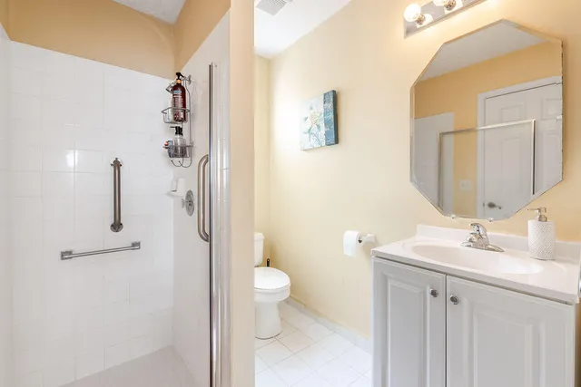 a bathroom with a sink a toilet and shower