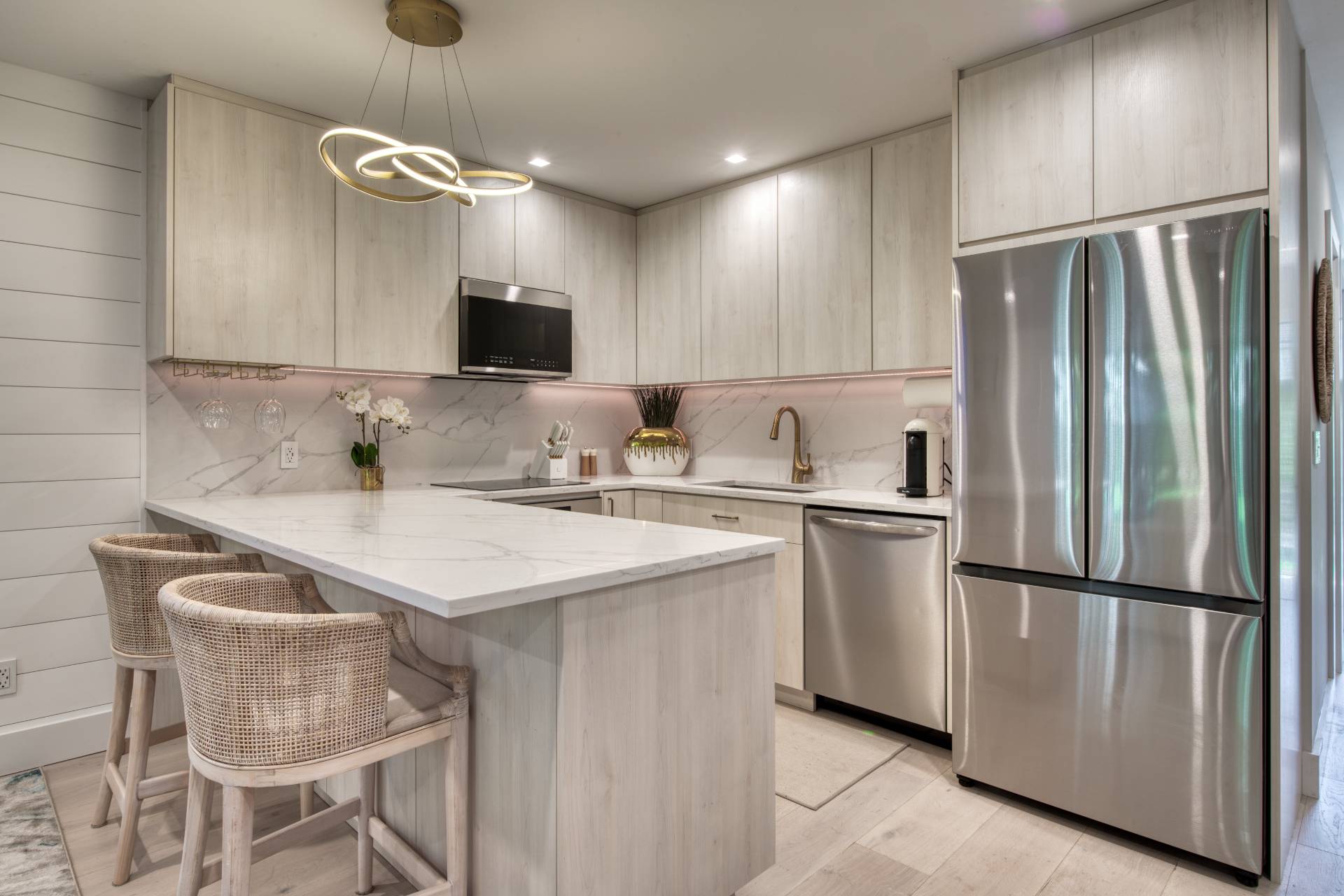 18 Bridge Street, Unit 2C Sag Harbor, NY 11963 - Photo 4 of 12 a kitchen with stainless steel appliances granite countertop a sink a stove a refrigerator and a refrigerator with wooden floor