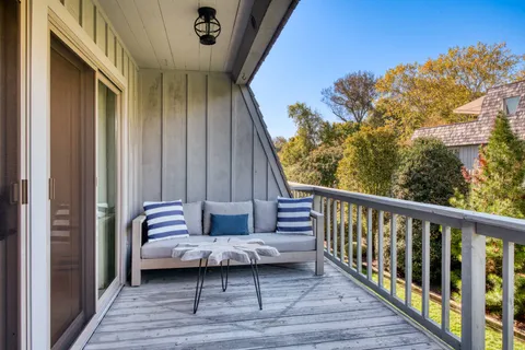 a view of a balcony with furniture and wooden floor