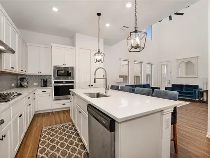 a kitchen with a stove a sink a microwave oven a stove and a center island