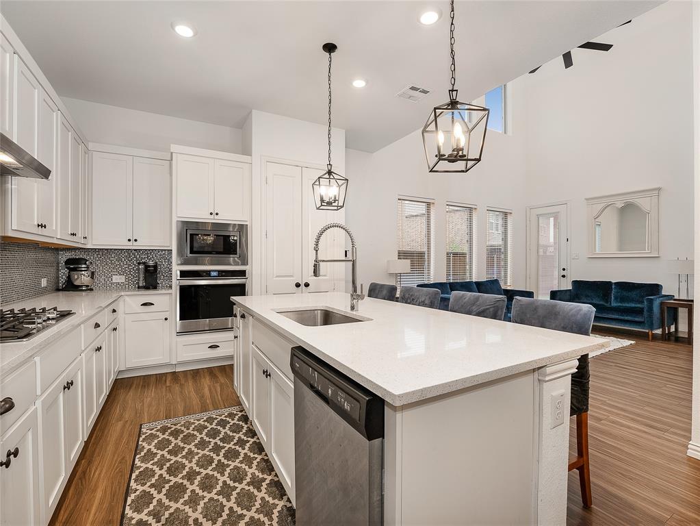 223 Woodson Street Irving, TX 75063 - Photo 18 of 40 a kitchen with a stove a sink a microwave oven a stove and a center island
