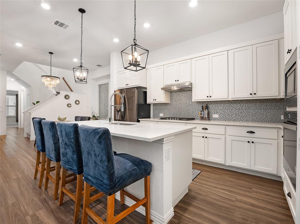 223 Woodson Street Irving, TX 75063 - Photo 2 of 40 a kitchen with stainless steel appliances kitchen island granite countertop a stove a sink a refrigerator a center island and a cabinets