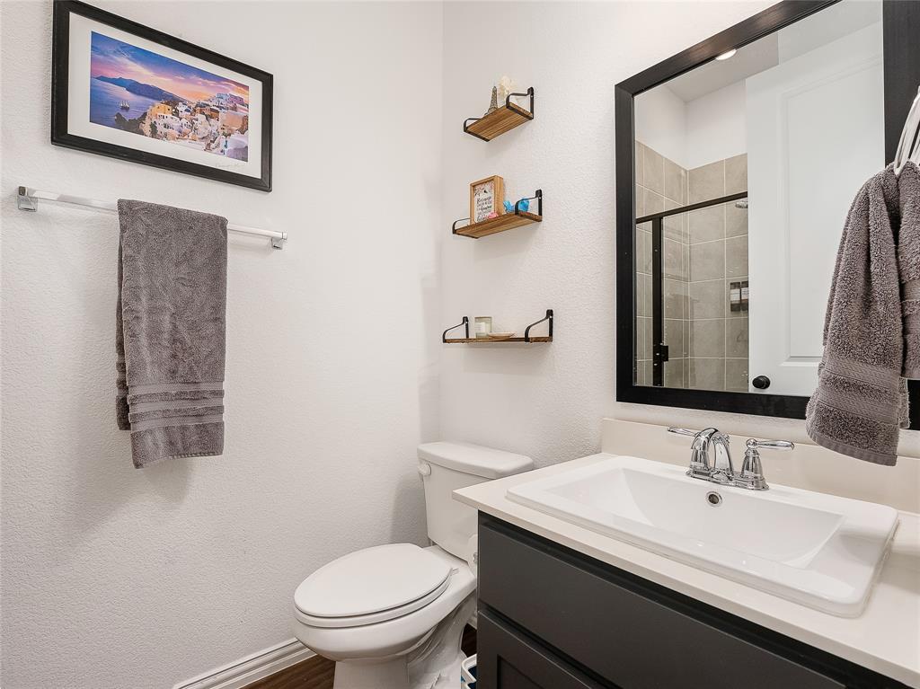 223 Woodson Street Irving, TX 75063 - Photo 24 of 40 a bathroom with a granite countertop sink mirror vanity and toilet