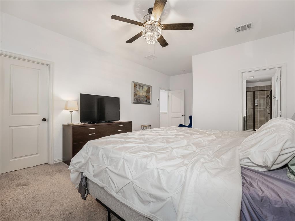 223 Woodson Street Irving, TX 75063 - Photo 25 of 40 a bedroom with a bed and a flat screen tv