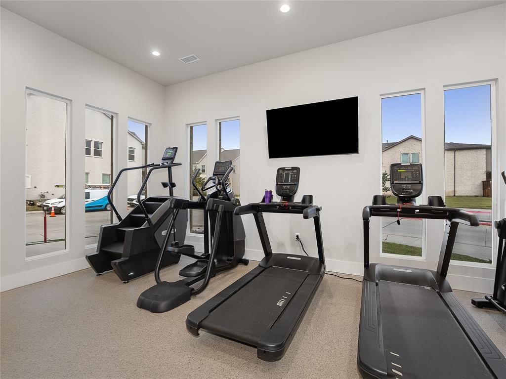 223 Woodson Street Irving, TX 75063 - Photo 37 of 40 a room with gym equipment and a flat screen tv