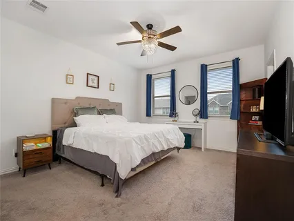 a bed room with a bed and a flat tv screen on dresser