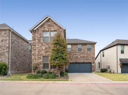 a front view of a house with a garden and garage