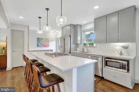 a kitchen with stainless steel appliances granite countertop a sink a stove and a refrigerator