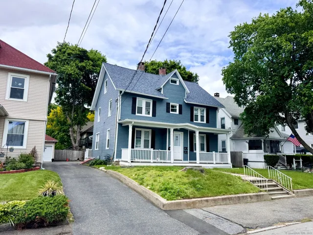 a front view of a house with a garden and plants