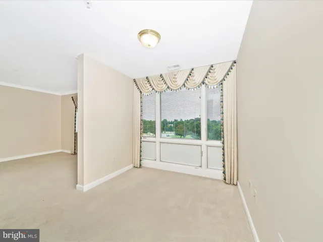 a view of a big room with windows and ceiling fan