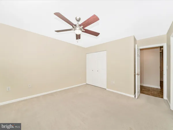 an empty room with a window and a ceiling fan