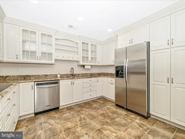 a kitchen with stainless steel appliances granite countertop a refrigerator and a stove top oven