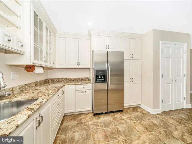 a kitchen with granite countertop a refrigerator and a sink