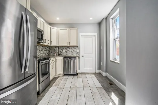 a kitchen with granite countertop stainless steel appliances a counter top space and cabinets