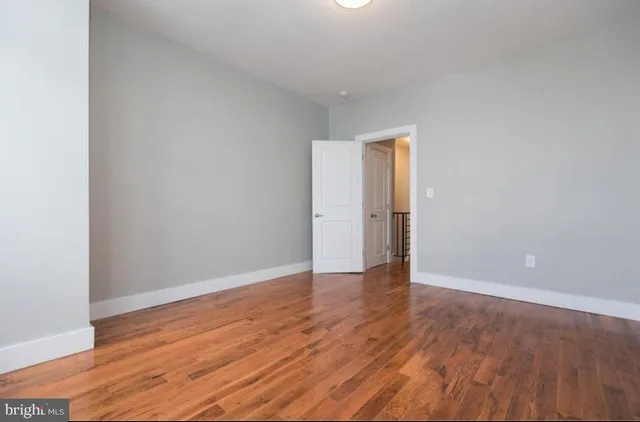 an empty room with wooden floor and closet