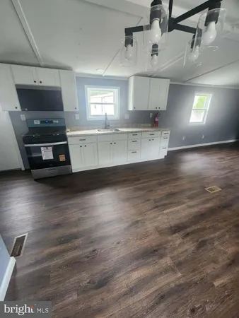 a kitchen with stainless steel appliances a stove and wooden floor